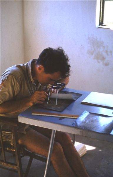 John Farrell, c.1960, studying aerial photographs of Lower Sabi vegetation.
